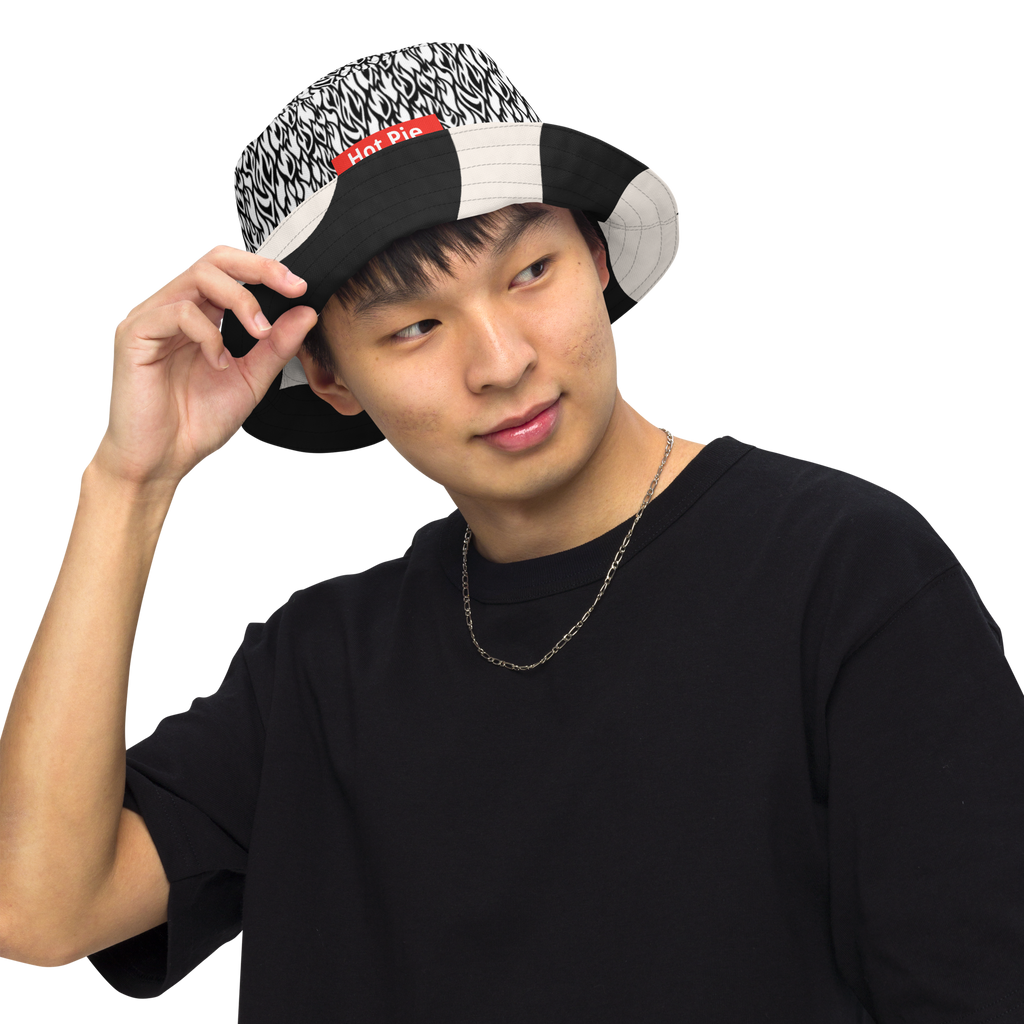 Person wearing a patterned cap and black shirt on a white background