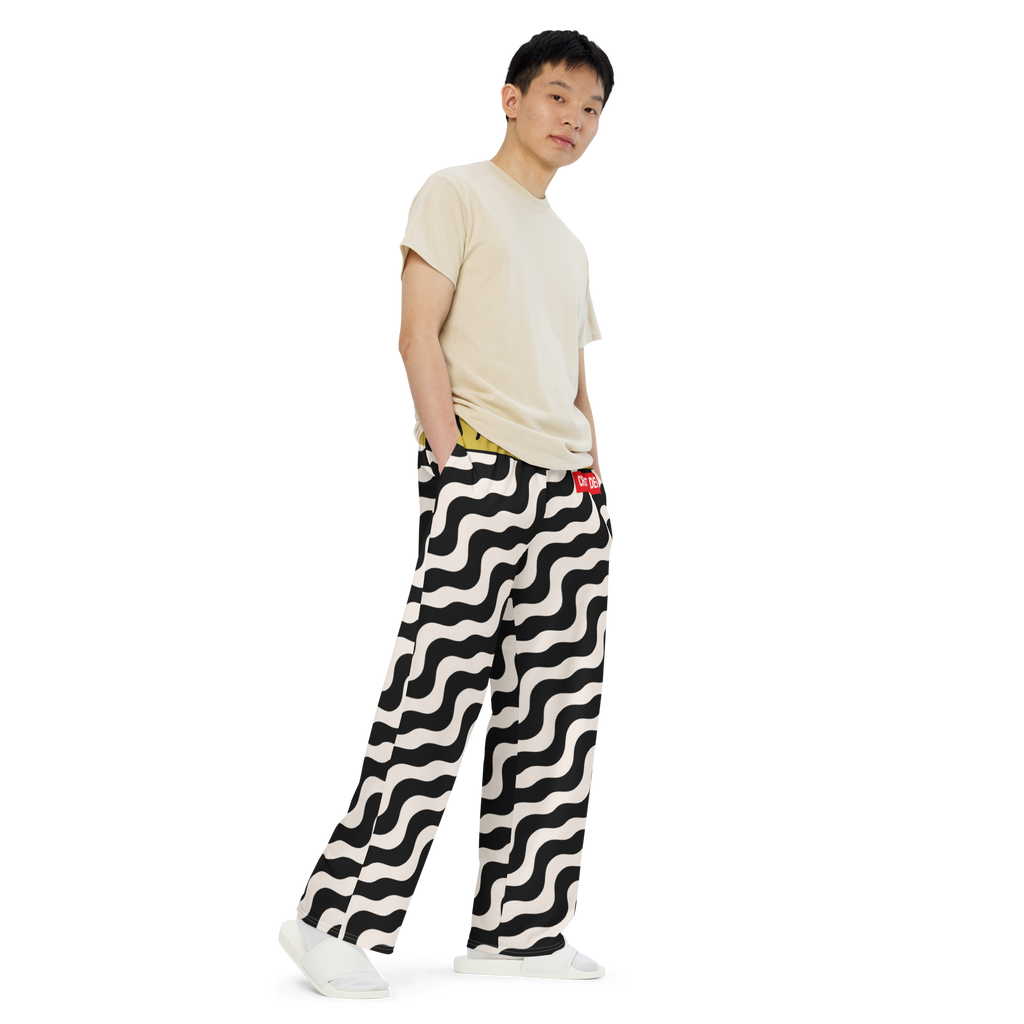 Person wearing a white t-shirt and black and white patterned pants on a white background
