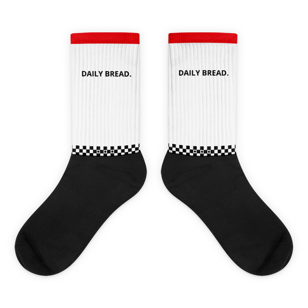 White socks with black cuffs and red tops, featuring 'DAILY BREAD.' text on a white background.