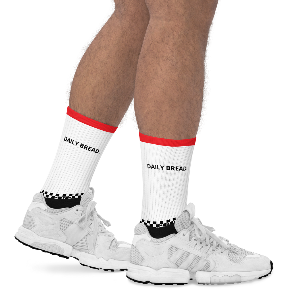 White socks with red accents and 'DAILY BREAD' branding worn with white sneakers on a white background.