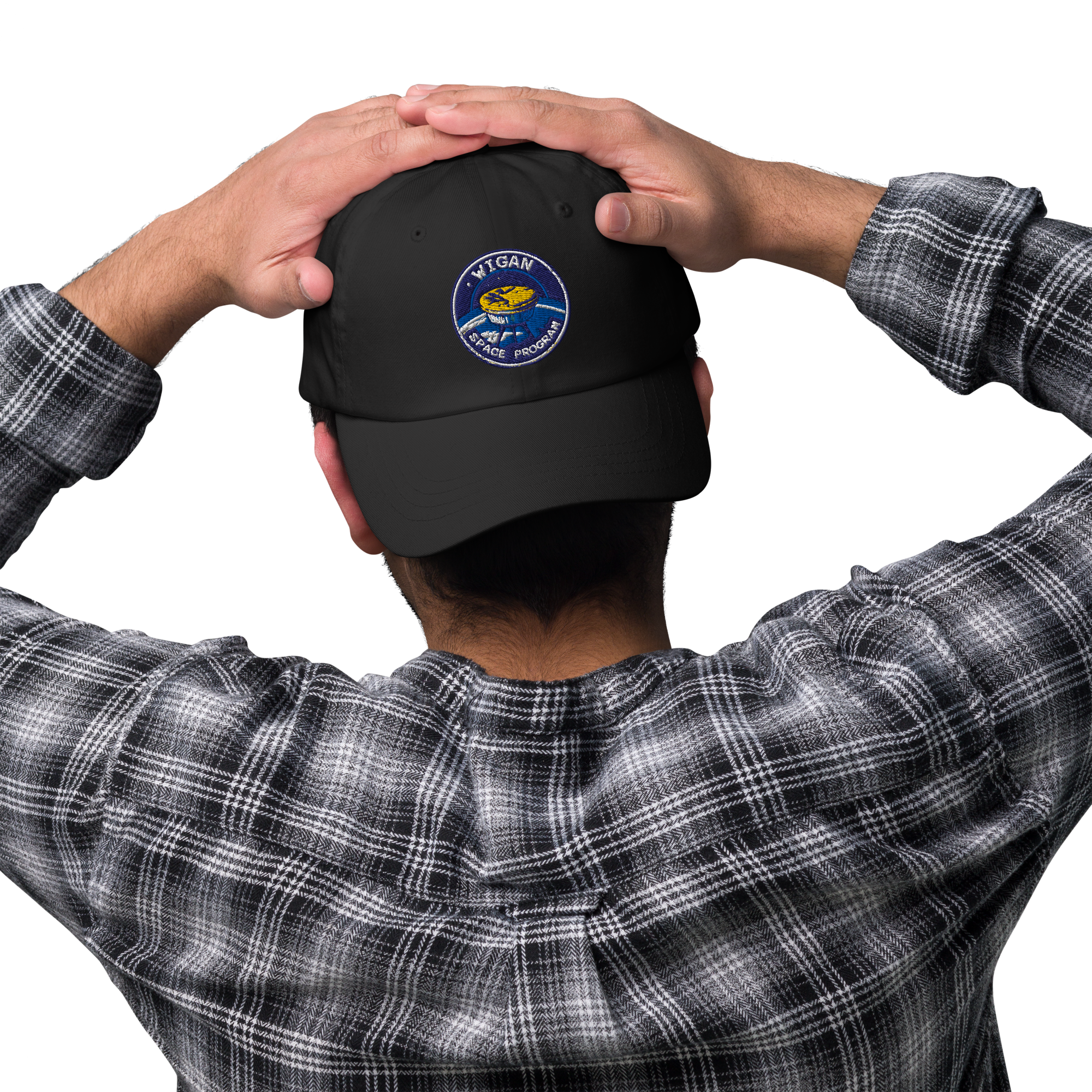 Person wearing a black cap with a logo, holding it on their head against a white background