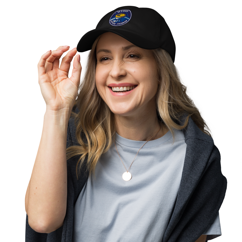 Woman wearing a black cap with a logo, smiling on a white background