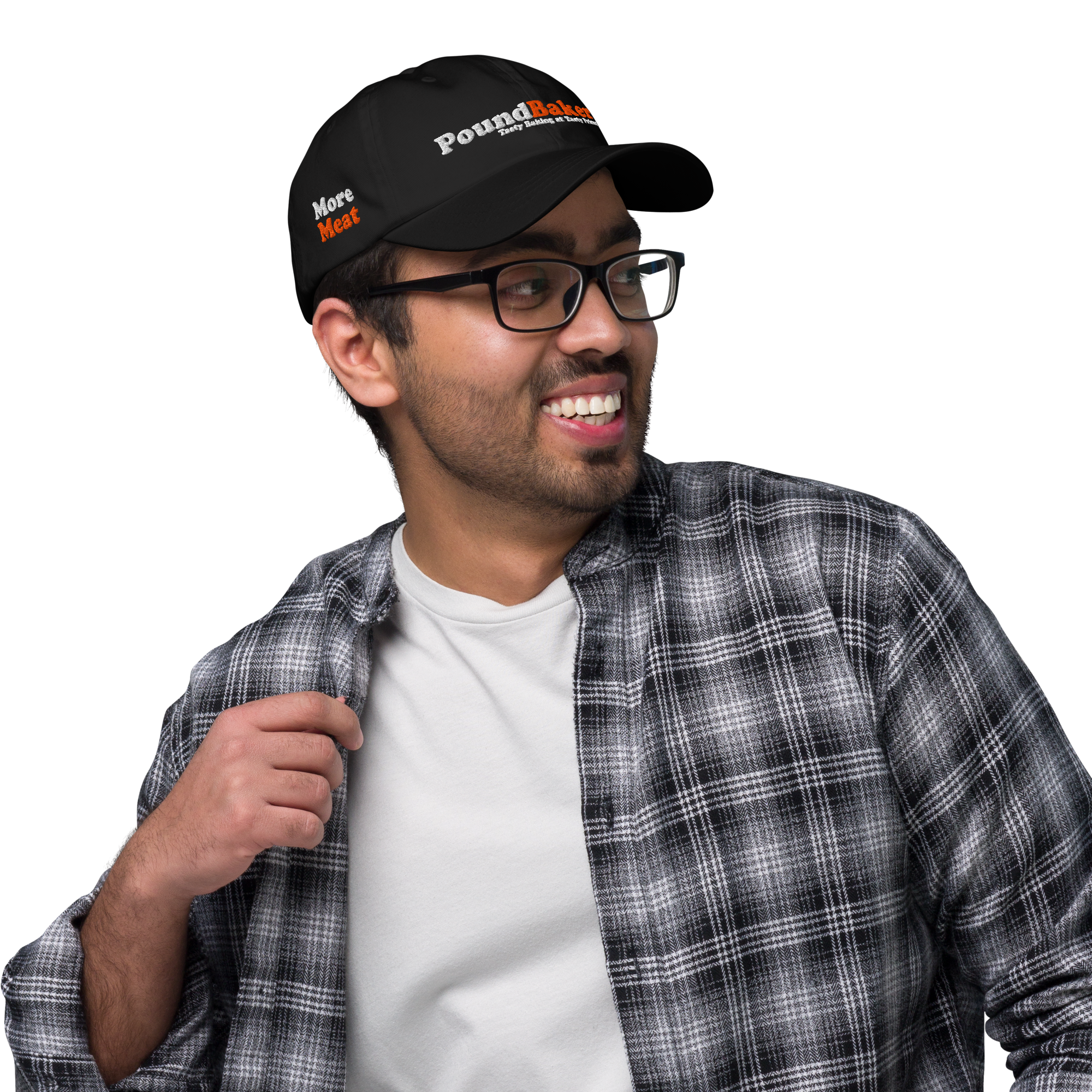 Man wearing a black cap with branding, glasses, and a plaid shirt over a white t-shirt on a white background