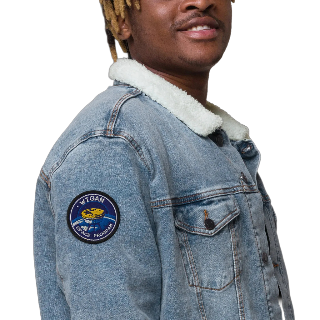 Person wearing a denim jacket with a patch on a white background