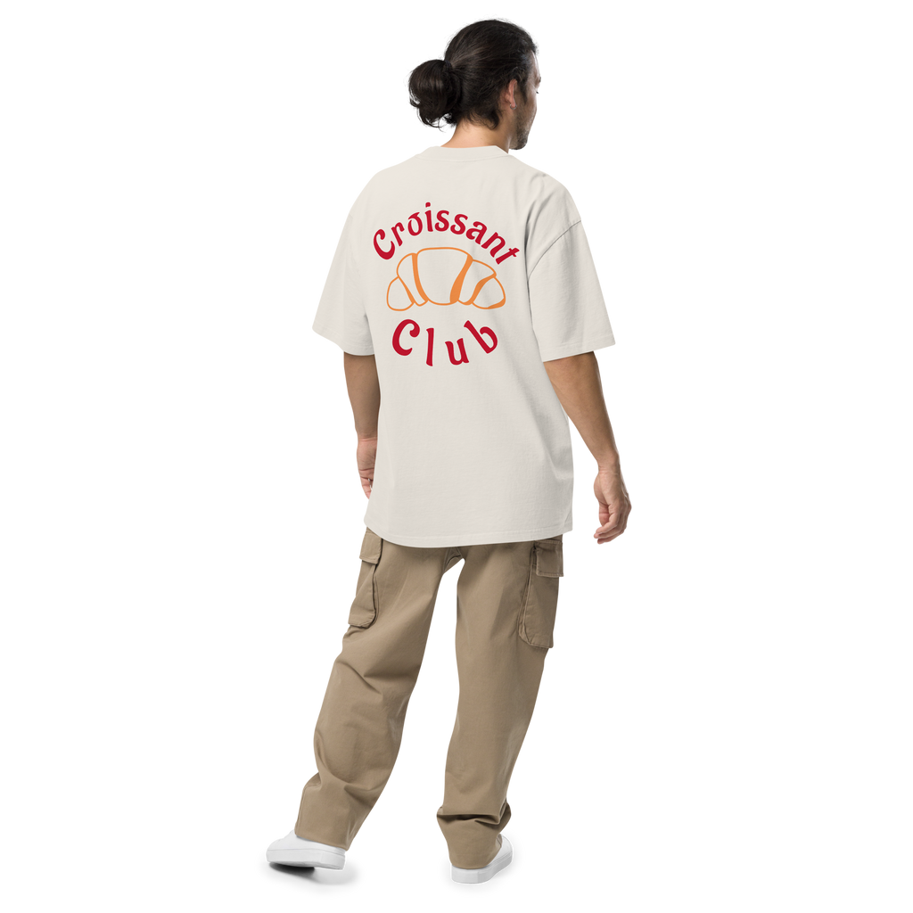 Person wearing a white t-shirt with 'Croissant Club' design on the back, standing against a white background.