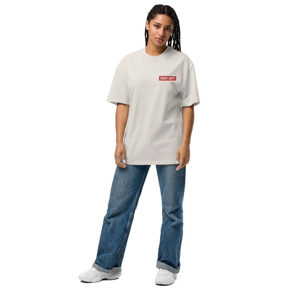 Person wearing a bone white t-shirt with a red Crust Dept. logo and blue jeans on a white background