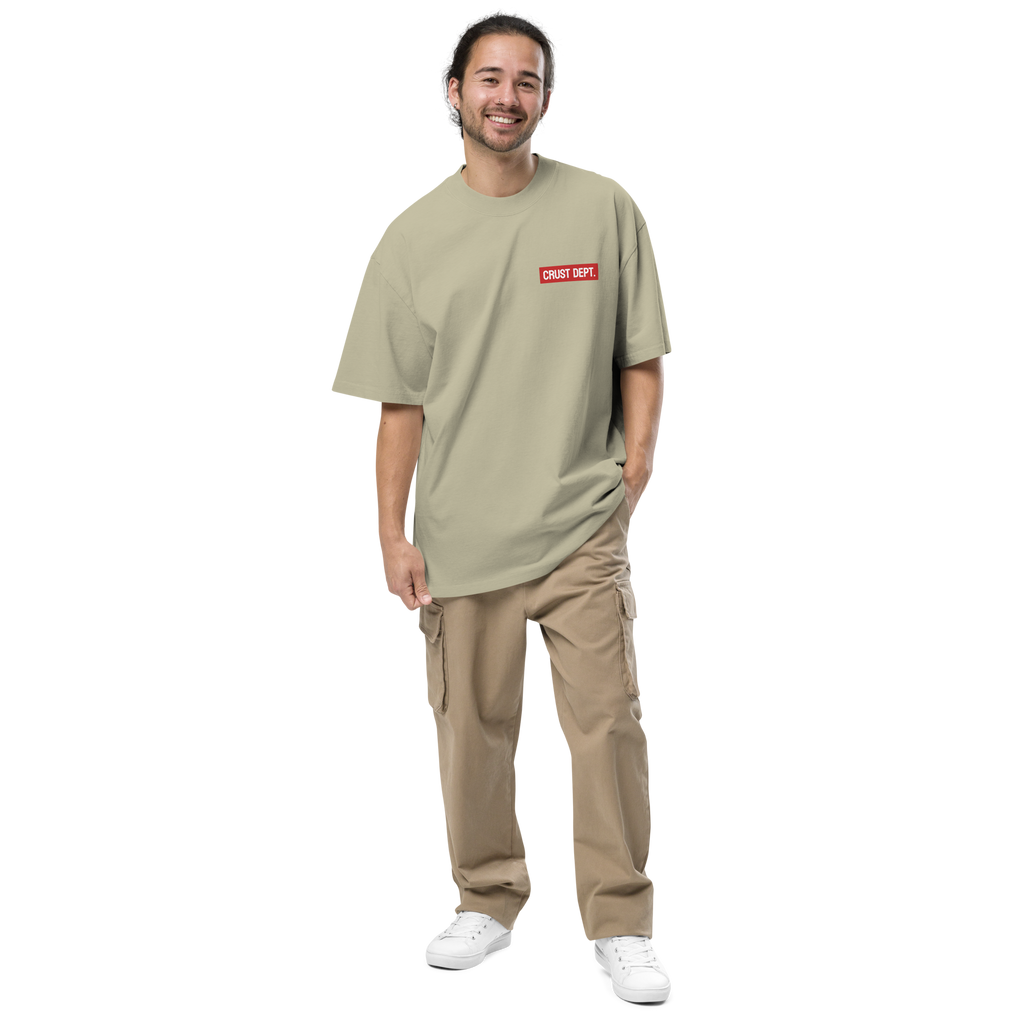 Man wearing a eucalyptus t-shirt with a red Crust Dept. logo and beige pants on a white background