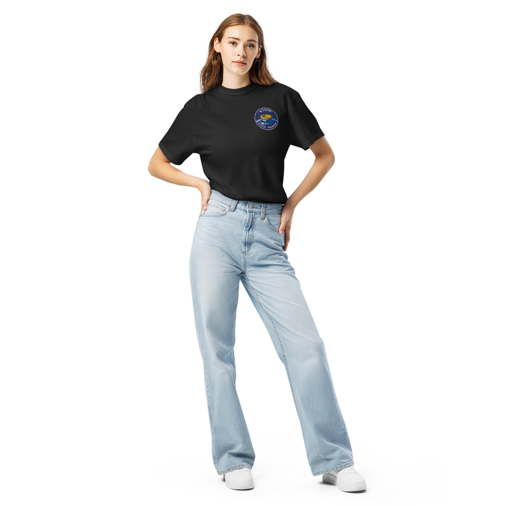 Woman wearing a black t-shirt with a logo and light blue jeans on a white background